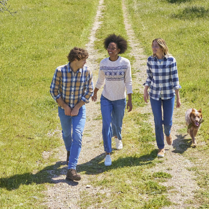 Photo with three people and a dog in a field