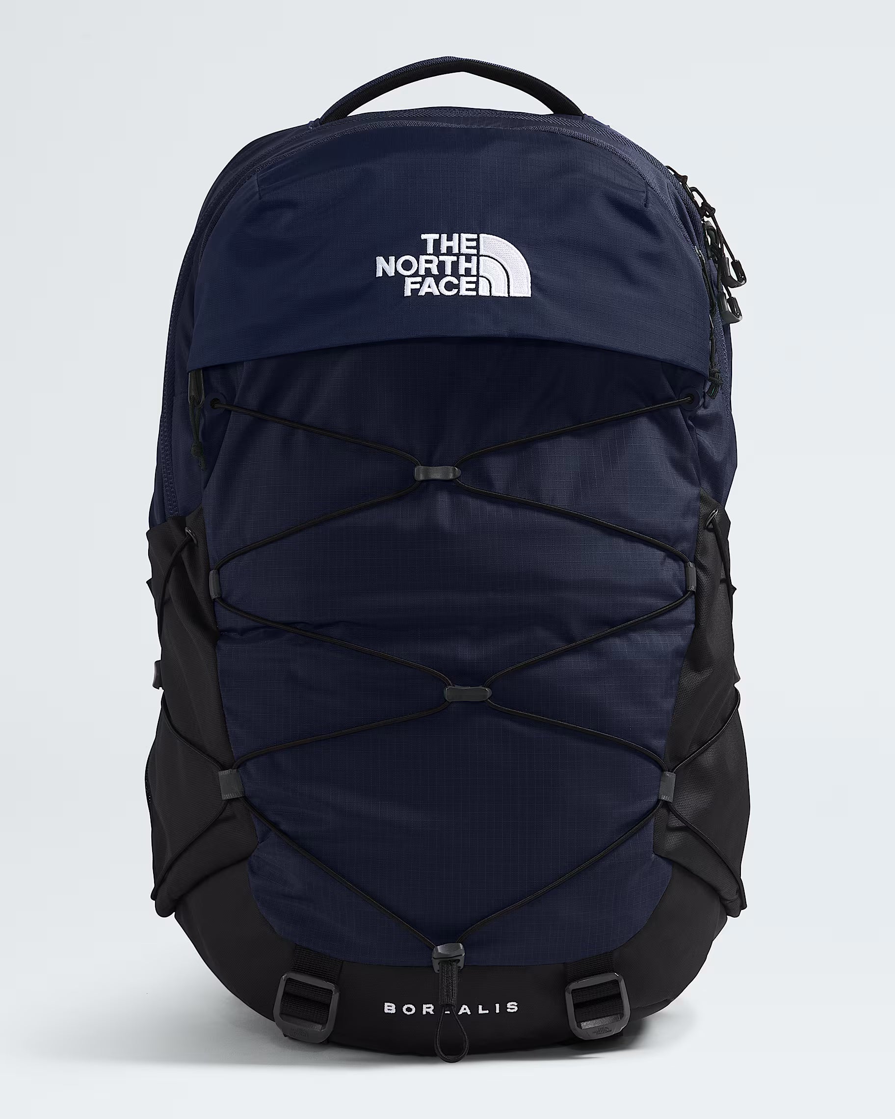 The North Face Boreal backpack in navy blue and black, featuring a white logo on the front flap and a white 'BORALIS' text on the bottom base, shown against a light gray background.