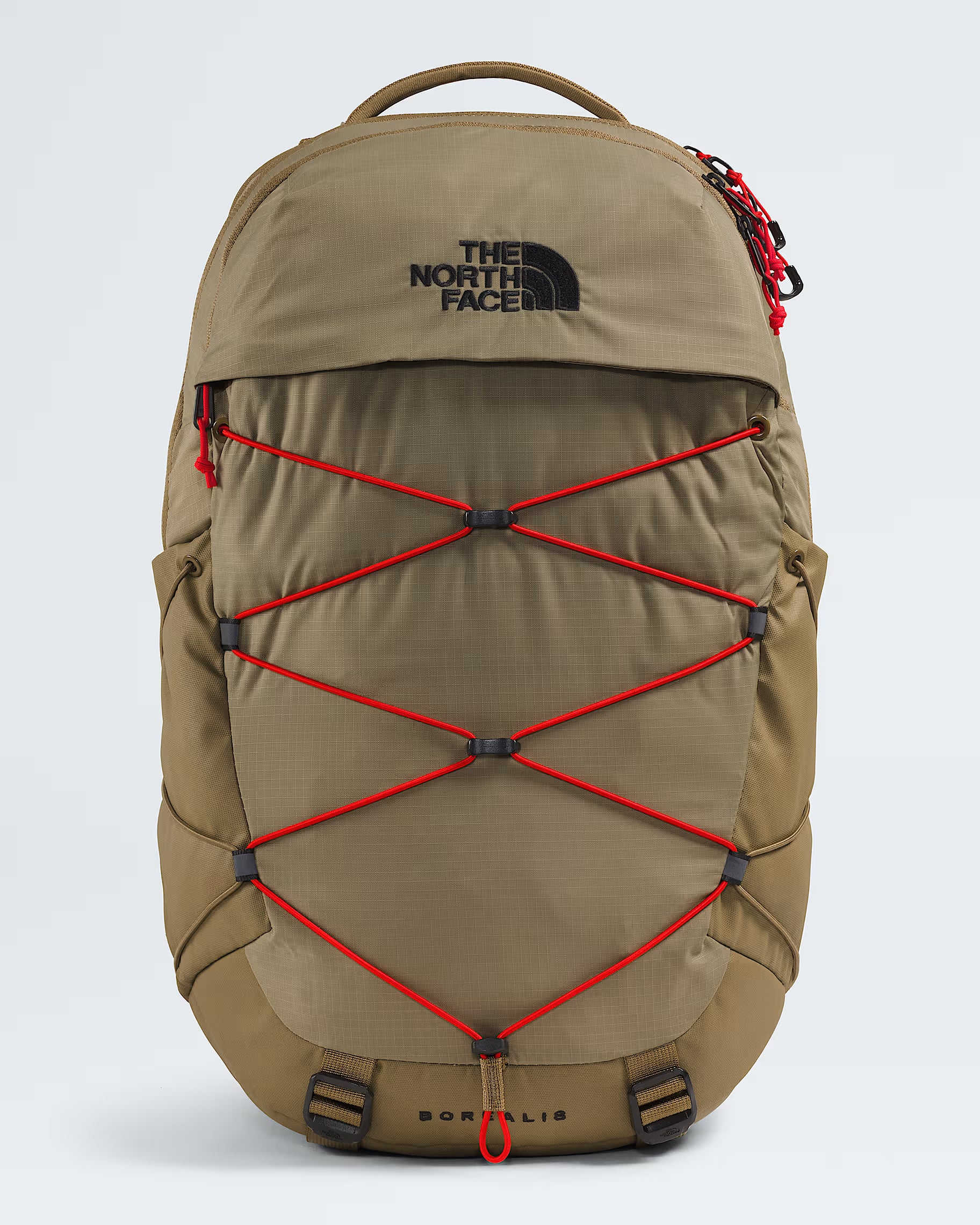 The North Face Sortlis backpack in a warm khaki-tan color, featuring red compression straps across the front and a black embroidered logo on the upper front panel, set against a light gray studio background.