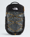The North Face Bortlis backpack in black and dark gray with a white map print, featuring orange bungee cords and orange zipper pulls, shown on a light gray background.