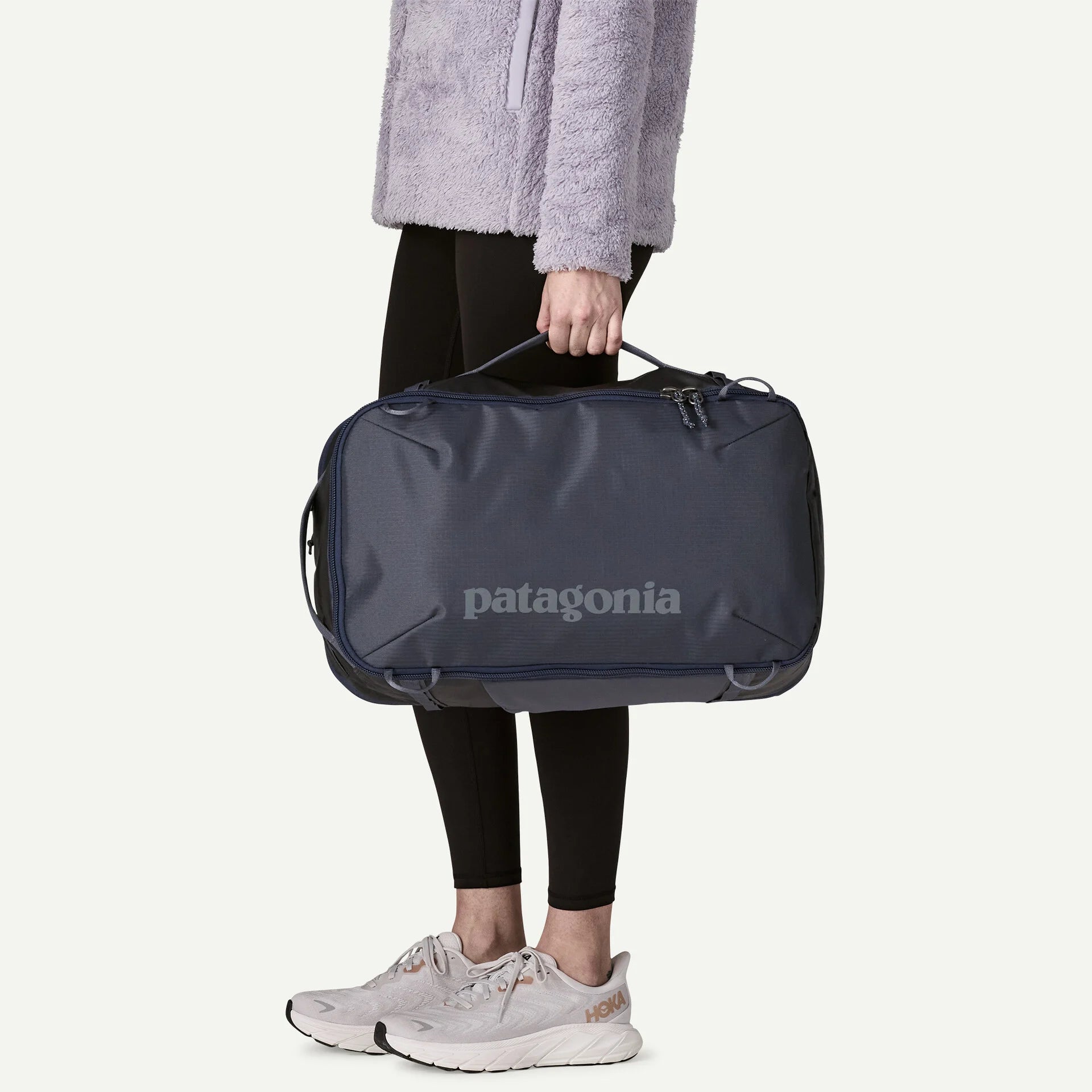 Person holding a Patagonia duffel bag on a white background