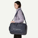 Woman carrying a Patagonia duffel bag on a white background
