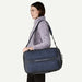 Woman carrying a navy blue duffel bag on a white background